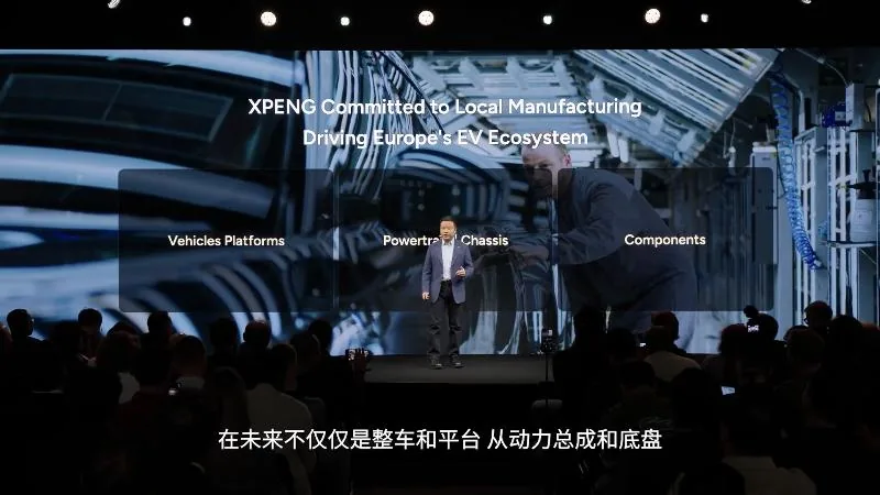 He Xiaopeng on stage in Paris in front of a slide headed ‘XPENG Committed to Local Manufacturing · Driving Europe’s EV Ecosystem’, with three panels: Vehicles and Platforms, Powertrain and Chassis, Components. A Chinese subtitle runs along the bottom.